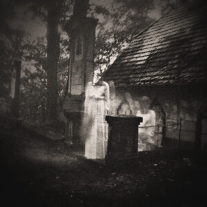Picture of an old church and cemetery. Amongst the stones, there are spirits or apparitions in white. Source Pixabay.com.